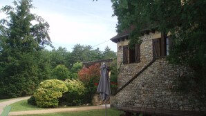 Ein Steinhaus mit Garten, Sitzgelegenheiten im Freien und einem Weg.
