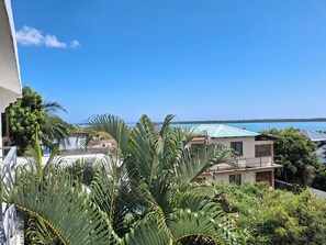 A residential area with a view of the sea, surrounded by lush greenery and houses with blue roofs. - La Gaulette Grand Loft, Pool & Panoramic Sea View  (La Gaulette)