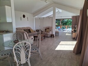 A spacious living area with a sofa, chairs, a glass dining table, and a view of the outdoors. - La Gaulette Grand Loft, Pool & Panoramic Sea View  (La Gaulette)