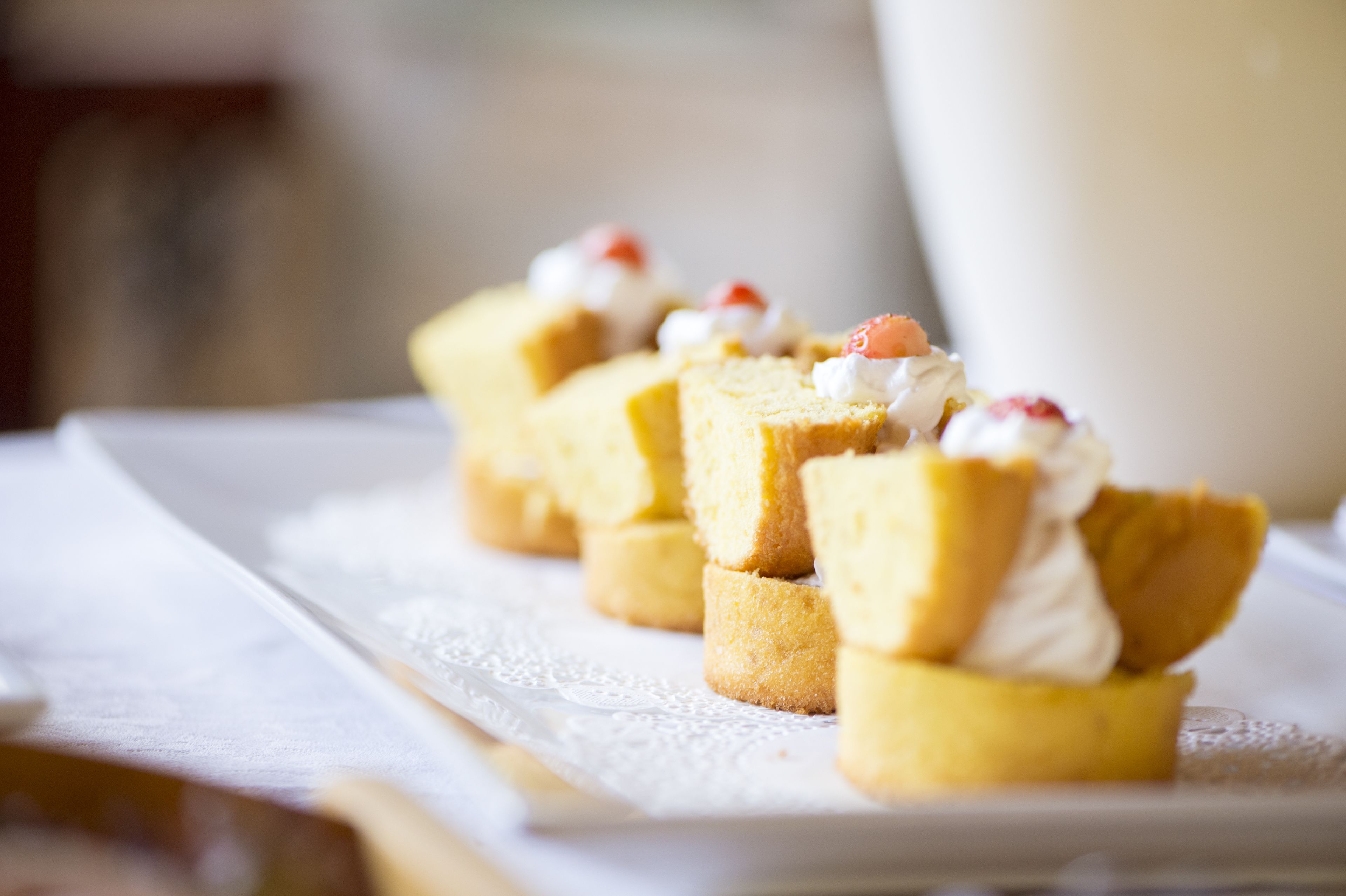 Un plateau de desserts avec de petits gâteaux recouverts de crème fouettée et de fruits.