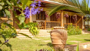 A house with a patio, a large terracotta pot, and hanging flower baskets. - Villa Kololo Guest House (Kampala)