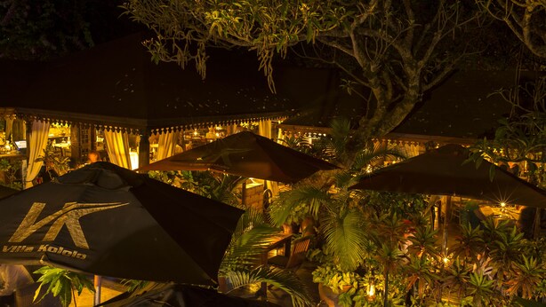 A well-lit outdoor dining area with umbrellas and potted plants. - Villa Kololo Guest House (Kampala)