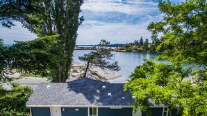 A two-story house with a deck, a small porch, and a view of a lake. - Unique Waterfront Beach House, 1 mile from Friday Harbor (Friday Harbor)