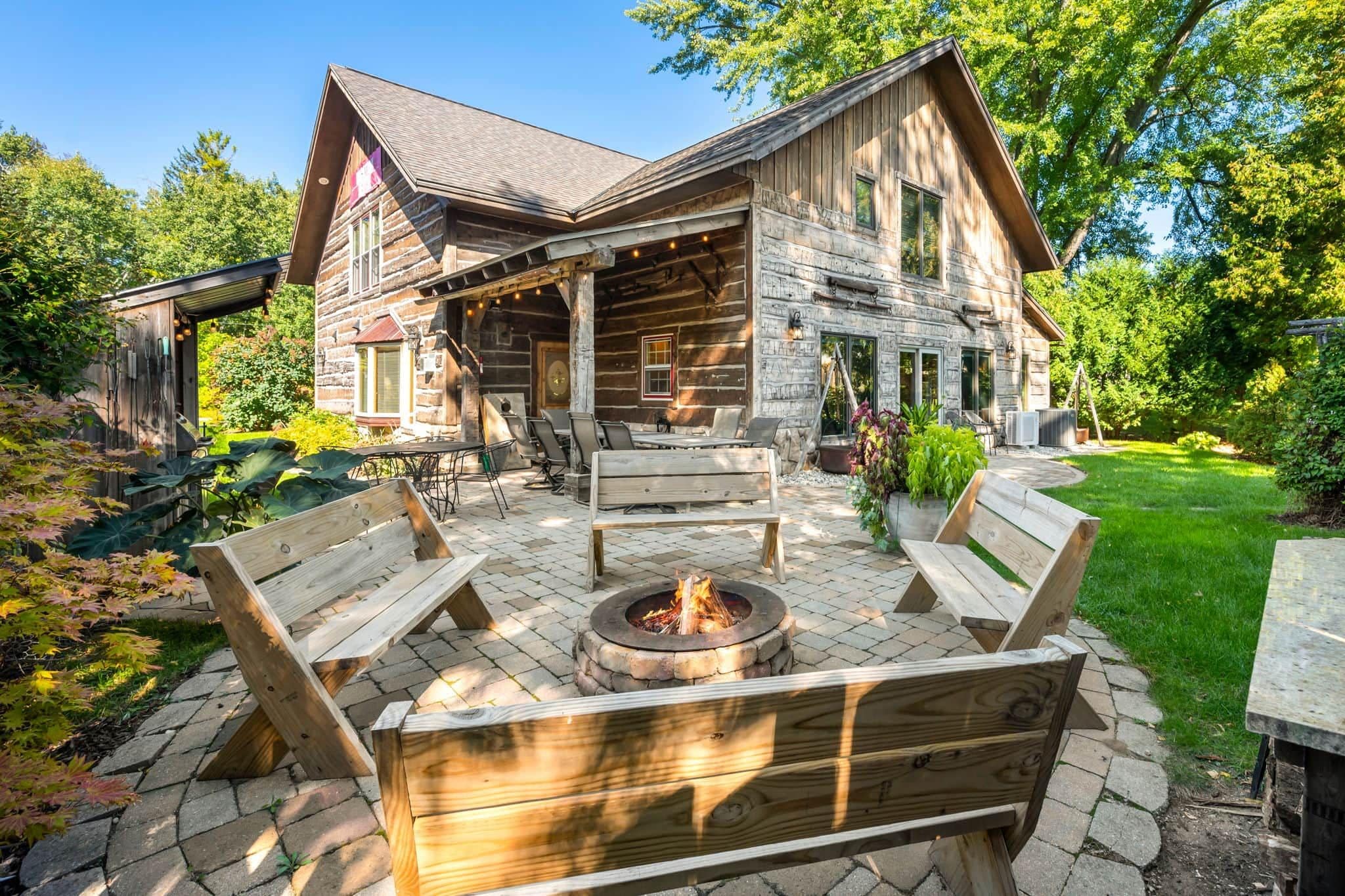 A log cabin with a fire pit and outdoor seating.