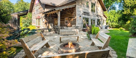 A log cabin with a fire pit and outdoor seating.