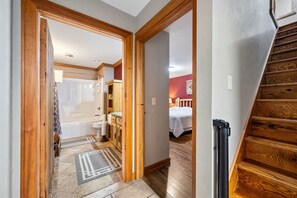 A hallway leading to a bathroom with a shower, toilet, and sink. - Peninsula Lodge Fish Creek (Gibraltar)