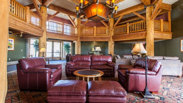 A spacious lobby with a high ceiling, wooden beams, and a large seating area with leather sofas and ottomans. - Sunstone #329 Ski In Ski Out! 2 Bedroom 2 Bath (Mammoth Lakes)