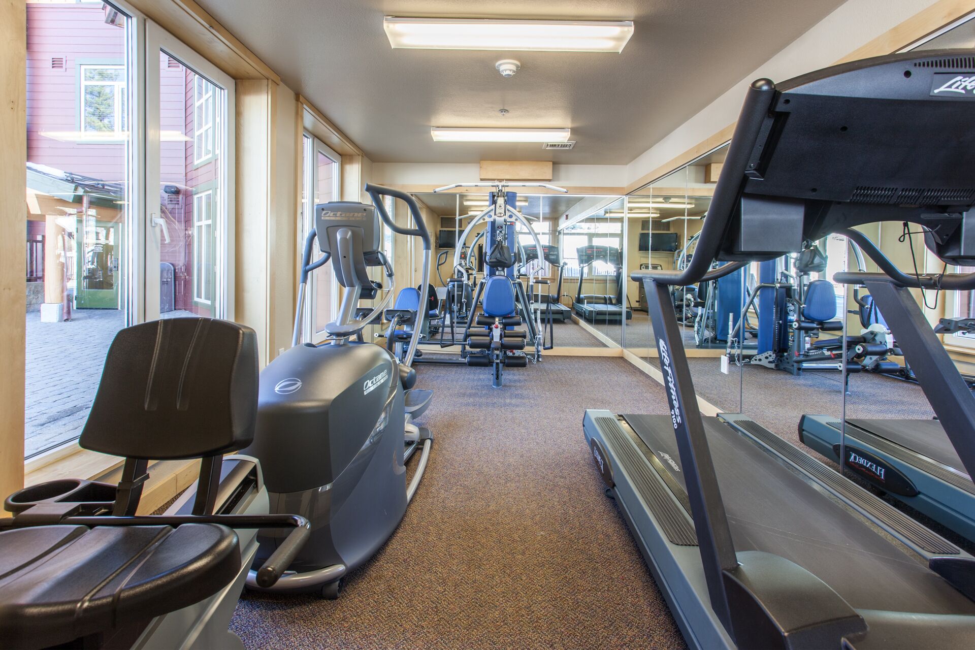 Academia com esteiras, elípticos e equipamentos de musculação.