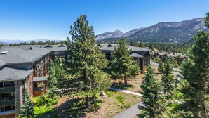 A resort with multiple buildings, surrounded by trees and mountains. - Sunstone #329 Ski In Ski Out! 2 Bedroom 2 Bath (Mammoth Lakes)