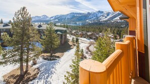 A mountain lodge with a view of snow-covered peaks and a forested valley. - Sunstone #329 Ski In Ski Out! 2 Bedroom 2 Bath (Mammoth Lakes)