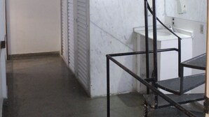 A modern bathroom with a marble wall, a sink, and a black metal staircase. - Tupiniquim Hostel Rio de Janeiro (Rio de Janeiro)