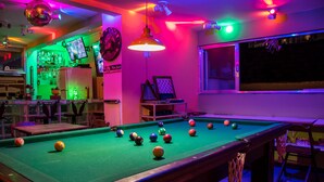 A pool table with balls, a bar area with a refrigerator and bottles, and a billiard cue rack. - Tupiniquim Hostel Rio de Janeiro (Rio de Janeiro)