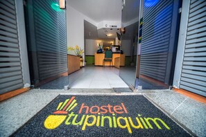 A hostel entrance with a reception desk and a doormat that reads "hostel tupiniquim". - Tupiniquim Hostel Rio de Janeiro (Rio de Janeiro)