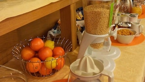 A breakfast buffet setup with various food items and utensils.