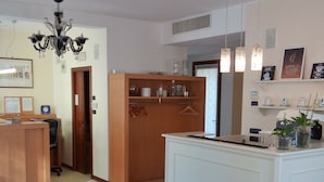 A modern kitchen with a central island, wooden cabinets, and pendant lighting.