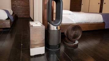 A room with a bed, a heater, and a fan.