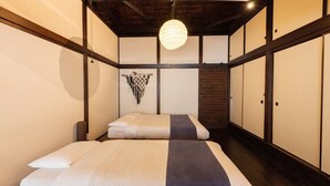 Une pièce de style japonais traditionnel, avec un sol recouvert de tatamis, un plafond bas et des paravents en papier de riz (shoji).