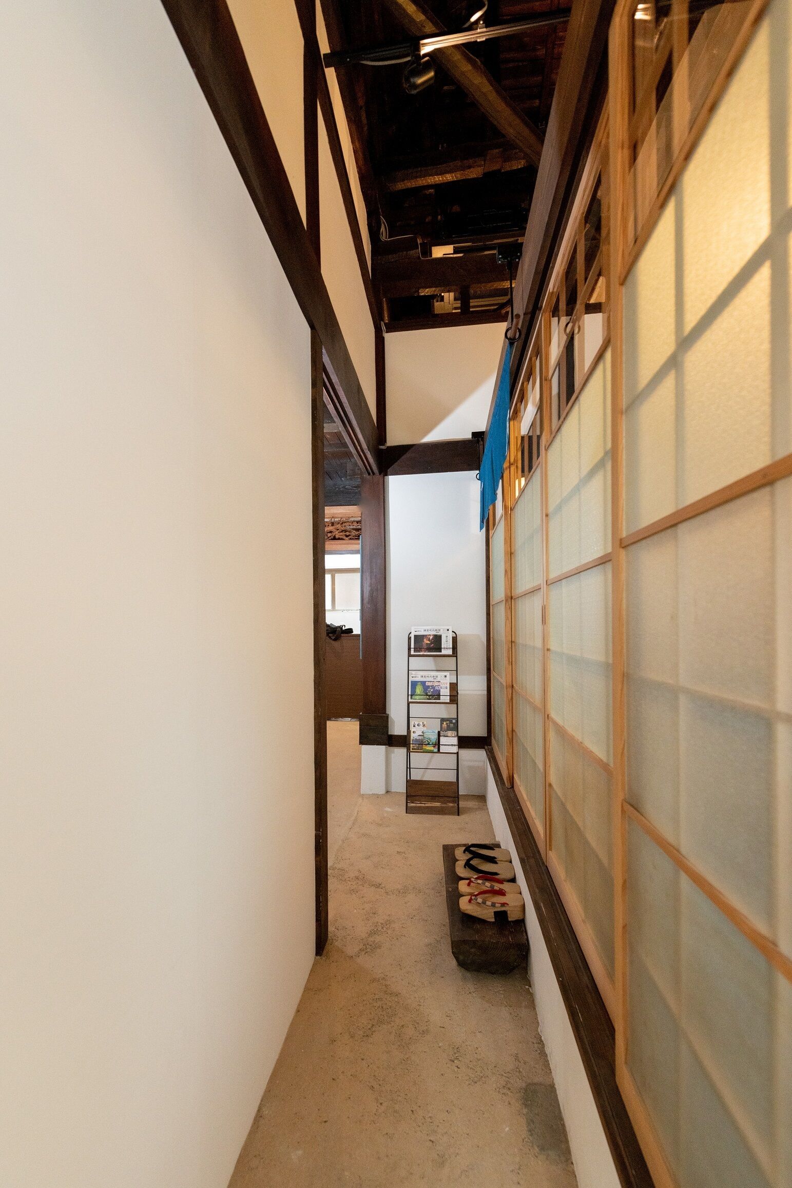 A narrow hallway with traditional wooden sliding doors and a concrete floor.