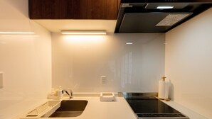 Une cuisine moderne équipée d’un four encastré, d’un évier et d’un plan de travail.