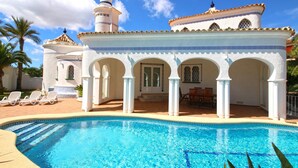 A pool area with a clear blue pool, white columns, and a covered seating area. - Luxurious Villa with air conditioning and pool Marquesa GU 6 People (Denia)