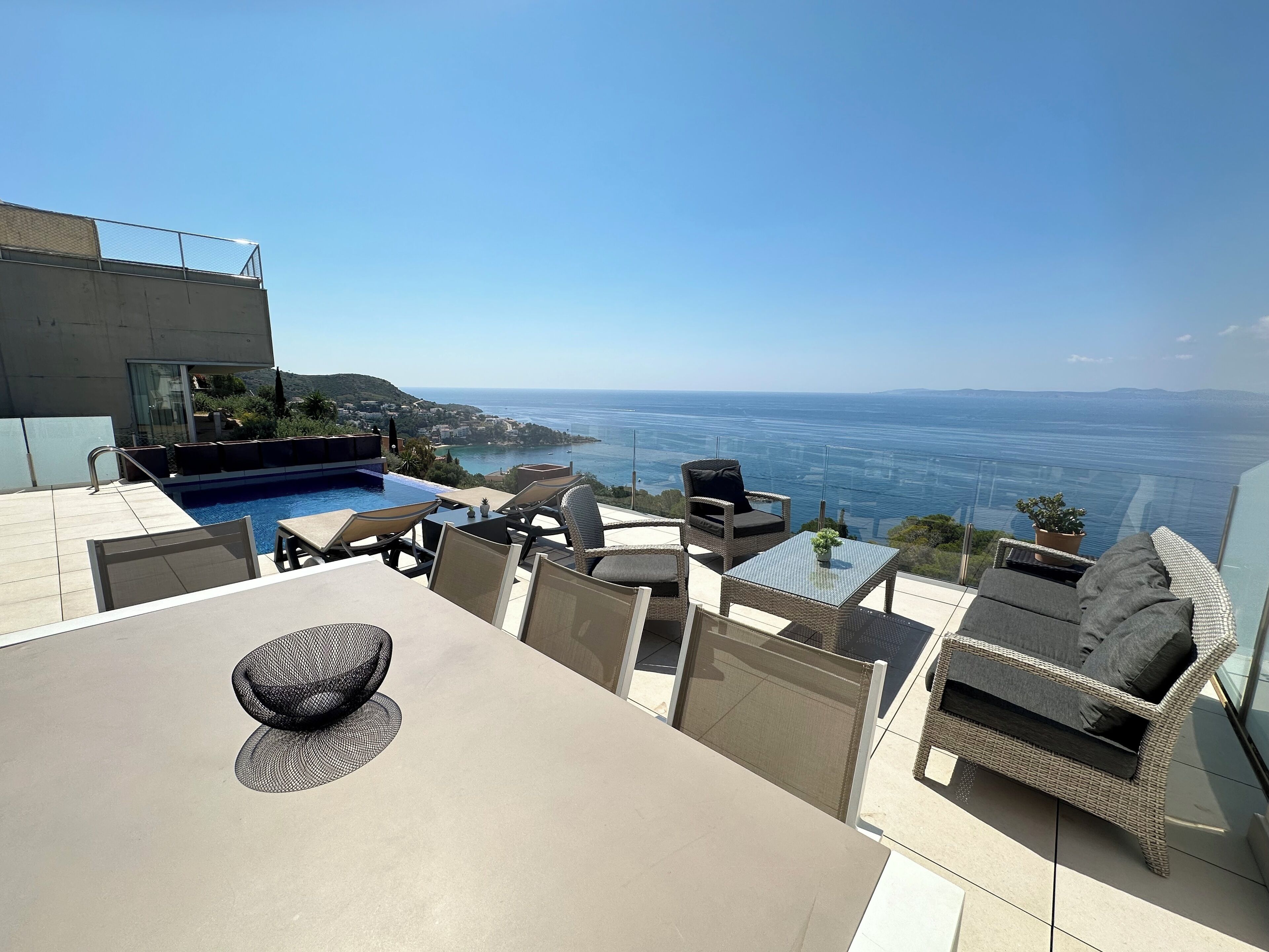 A rooftop terrace with a pool, outdoor seating, and a view of the sea.