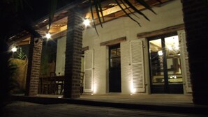 A building with a brick facade, large glass doors, and a wooden deck.
