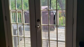 Un conjunto de puertas dobles con vista a una terraza y mobiliario exterior.