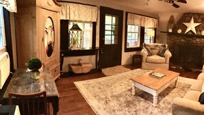A cozy living room with a fireplace, a coffee table, and a comfortable sofa. - StarField Cottage...The Perfect Cooperstown Dreams Park Getaway! (Cooperstown)