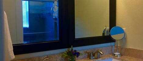 A bathroom with two sinks, a mirror, and a towel rack.