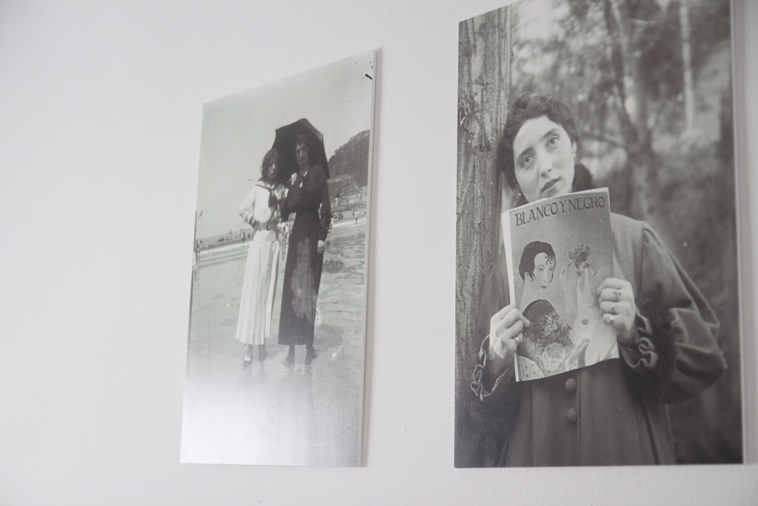Deux photographies en noir et blanc représentant des personnes, dont l’une tient un livre intitulé « BLANCO Y NEGRO ».
