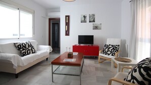 Ein modernes Wohnzimmer mit Sofa, Sesseln und einem kleinen Tisch.