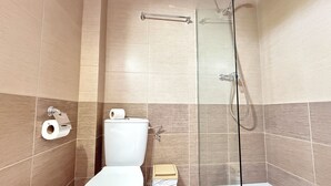 A bathroom with a toilet, a shower, and a glass-enclosed shower stall. - Agi Josep Sabate 42 Apartamento for rent in Roses Girona. (Rosas / Roses)