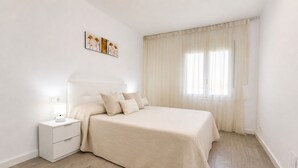 Een slaapkamer met een bed, nachtkastje en wanddecoratie.