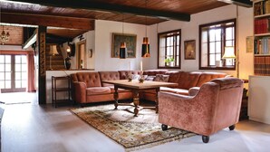 Ein gemütliches Wohnzimmer mit einem braunen Ledersofa, einem Holztisch und einem gemusterten Teppich.
