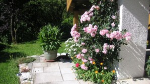 A garden with potted plants and blooming flowers. - Ferienwohnung, 55 qm, 2 Schlafzimmer, Balkon und Terrasse (Siegsdorf)