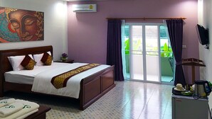 A hotel room with a large bed, a flat-screen TV, a ceiling fan, and a sliding glass door to the outside. - S Family Residence (Nikhom Kham Soi)