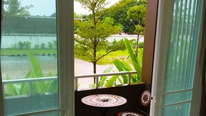 A room with a sliding glass door leading to an outdoor area with a small table and chairs. - S Family Residence (Nikhom Kham Soi)
