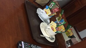 A dining table with a remote control, a calculator, and various food items. - S Family Residence (Nikhom Kham Soi)