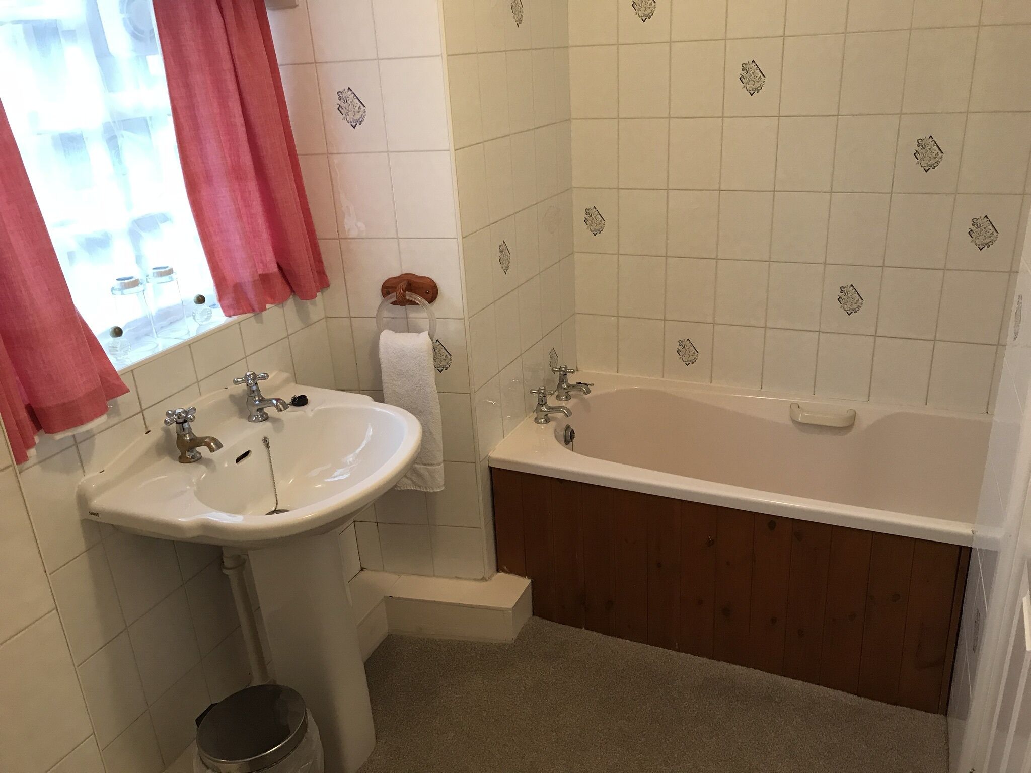 A bathroom with a sink, vanity, and bathtub.