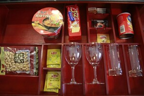 Un estante de madera con diversos alimentos y cristalería.