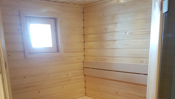 A wooden cabin with a bunk bed and a small window.