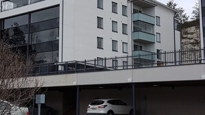 A modern building with a flat roof, large windows, and a parking garage.
