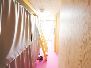 A hallway with a pink carpet, wooden walls, and a wooden ladder leaning against the wall. - Hostel J Culture168 (Toyonaka)