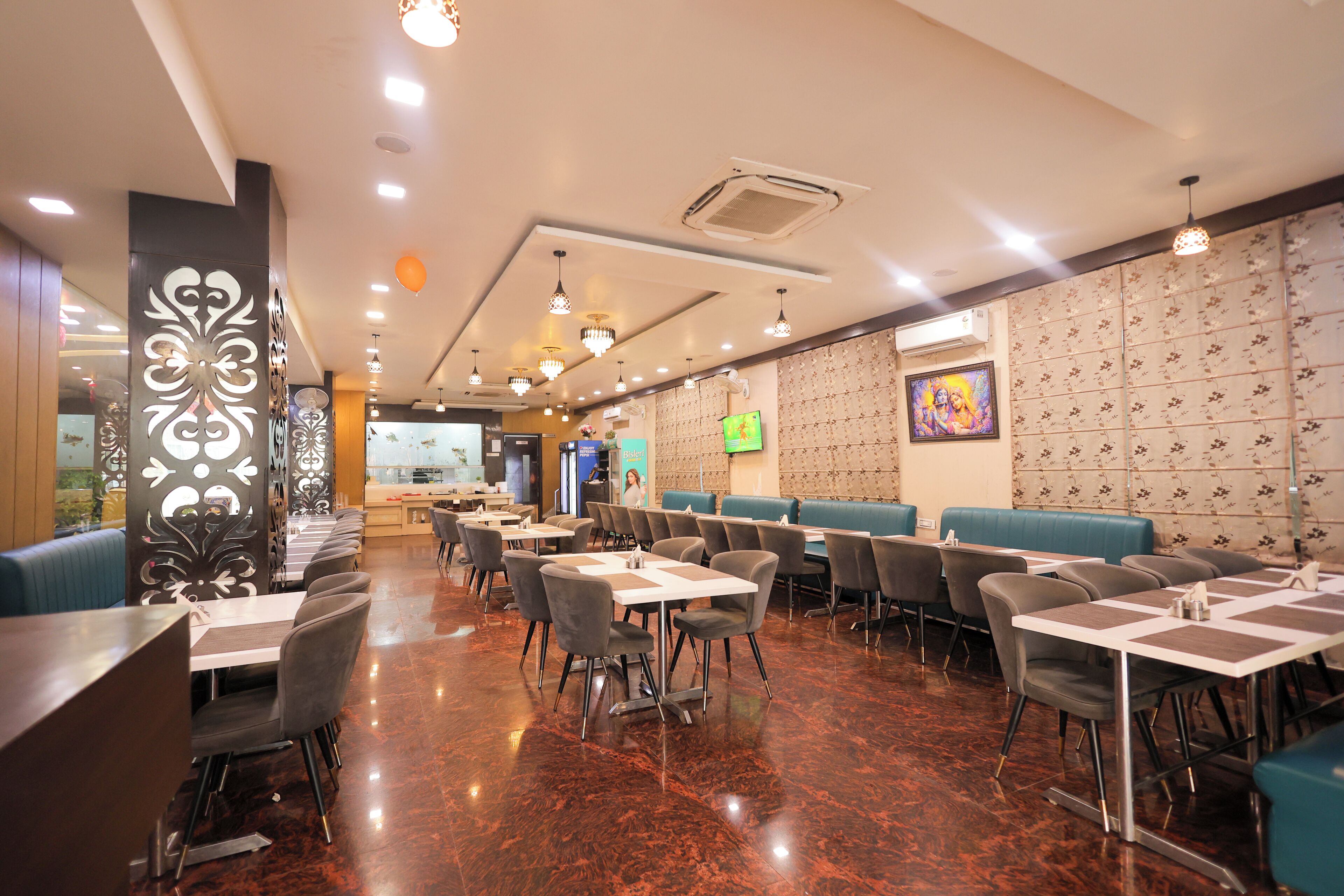 Un restaurante con cabinas y mesas, piso pulido y pared con diseño.