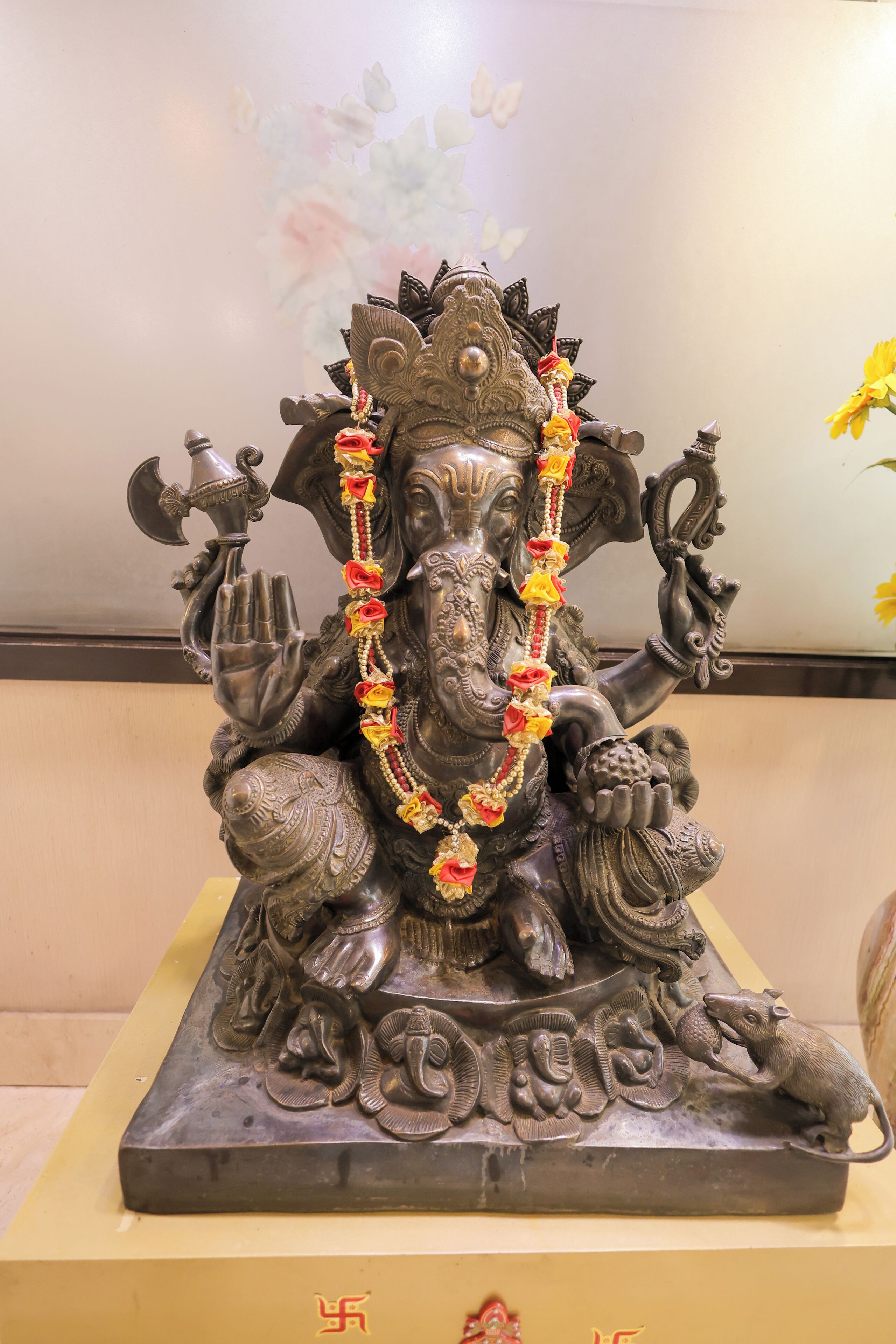 A statue of a deity with intricate carvings, seated on a pedestal.