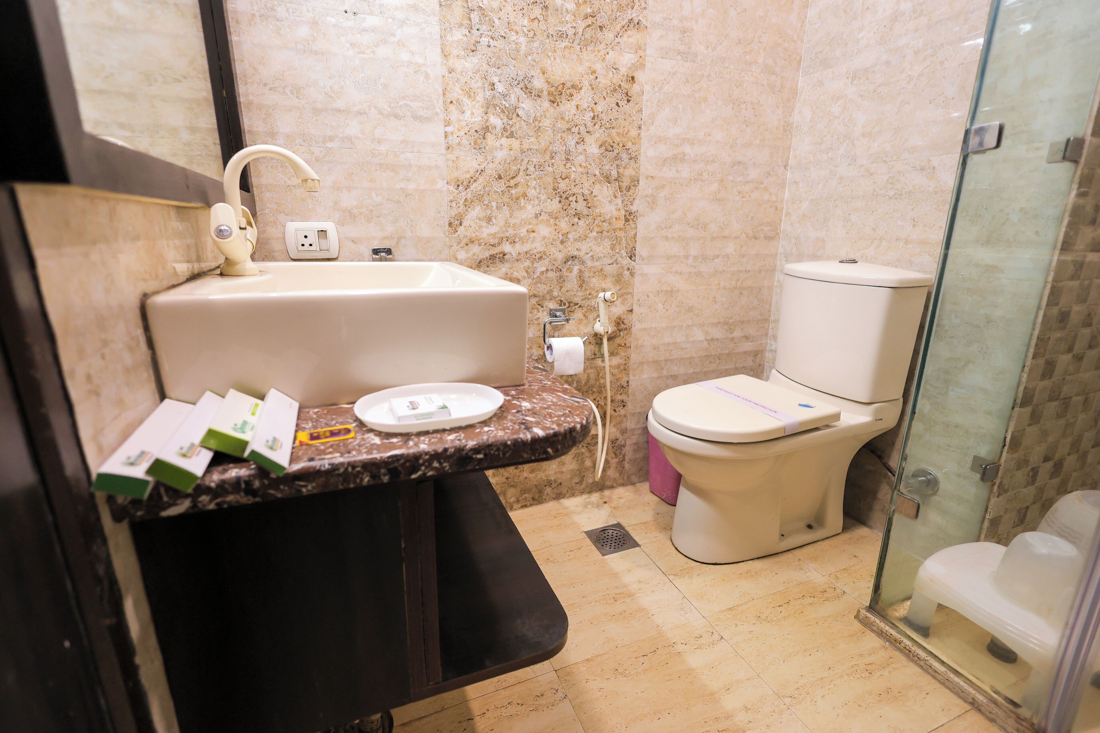 Un baño con lavamanos, inodoro y cabina de ducha de vidrio.