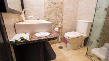 Un baño con lavamanos, inodoro y cabina de ducha de vidrio.