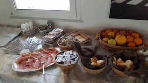 Una mesa de buffet con diversos alimentos, incluyendo carnes, quesos y frutas.