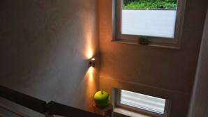 Portaat, joissa on kaide, vihreä omena pienen jakkaran päällä ja ikkuna, jossa on sälekaihtimet.