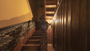 Una scala in legno con ringhiera intagliata e pavimento decorato.